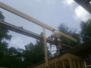 Carpenter setting a ridge beam over a new addition frame — Ice Dam Removal by Roofing Brothers in Flovilla