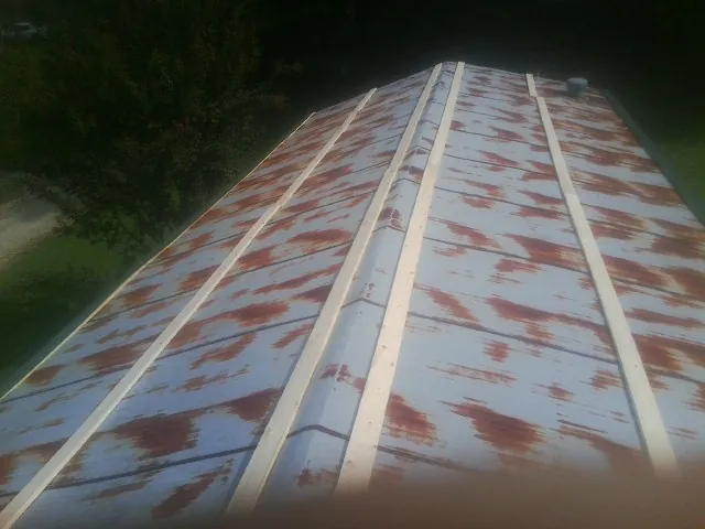Rusted metal roof panels with new wood purlins before replacement — Storm Damage Roof Repair in Flovilla by Roofing Brothers