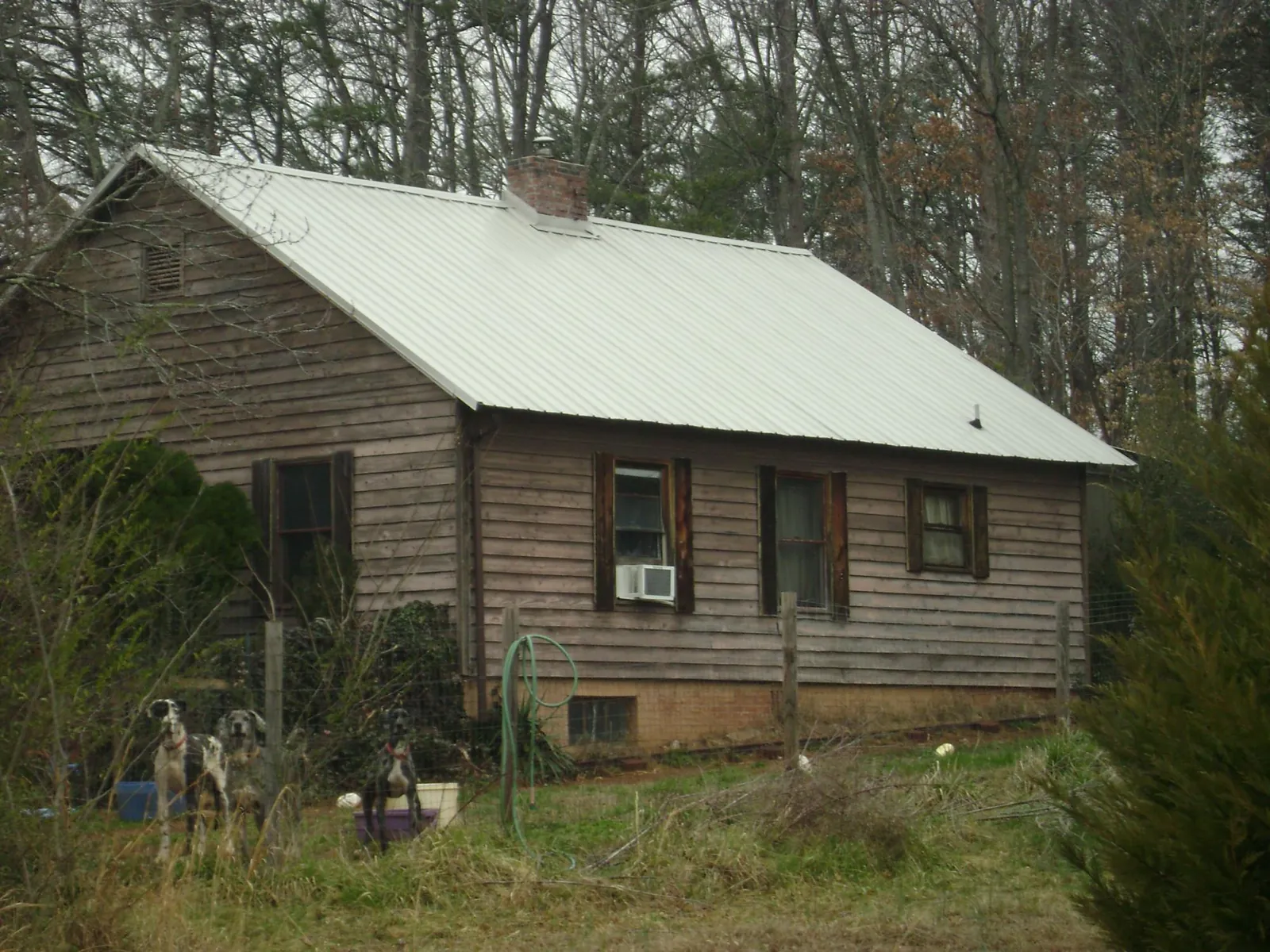 White metal roof on an old wood sided farmhouse, from a Metal Roof Installation job in Flovilla